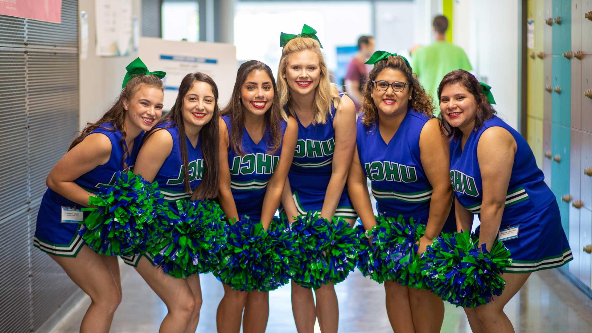 Spirit Squad smiling in blue and green uniforms